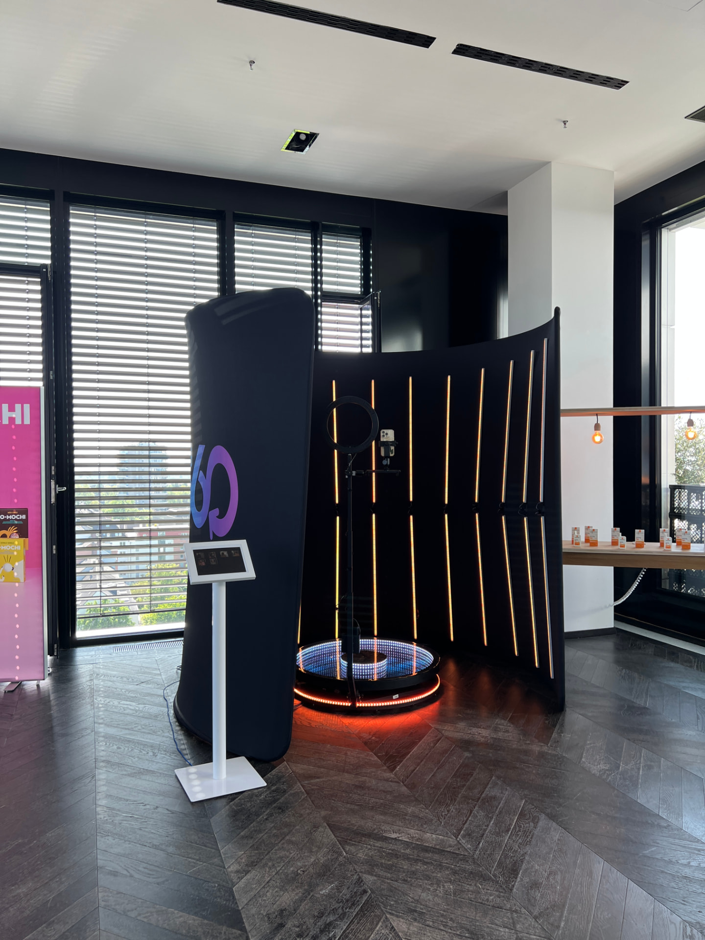 360° Video Booth mit Kundenlogo und Tablet-Station in einem Showroom