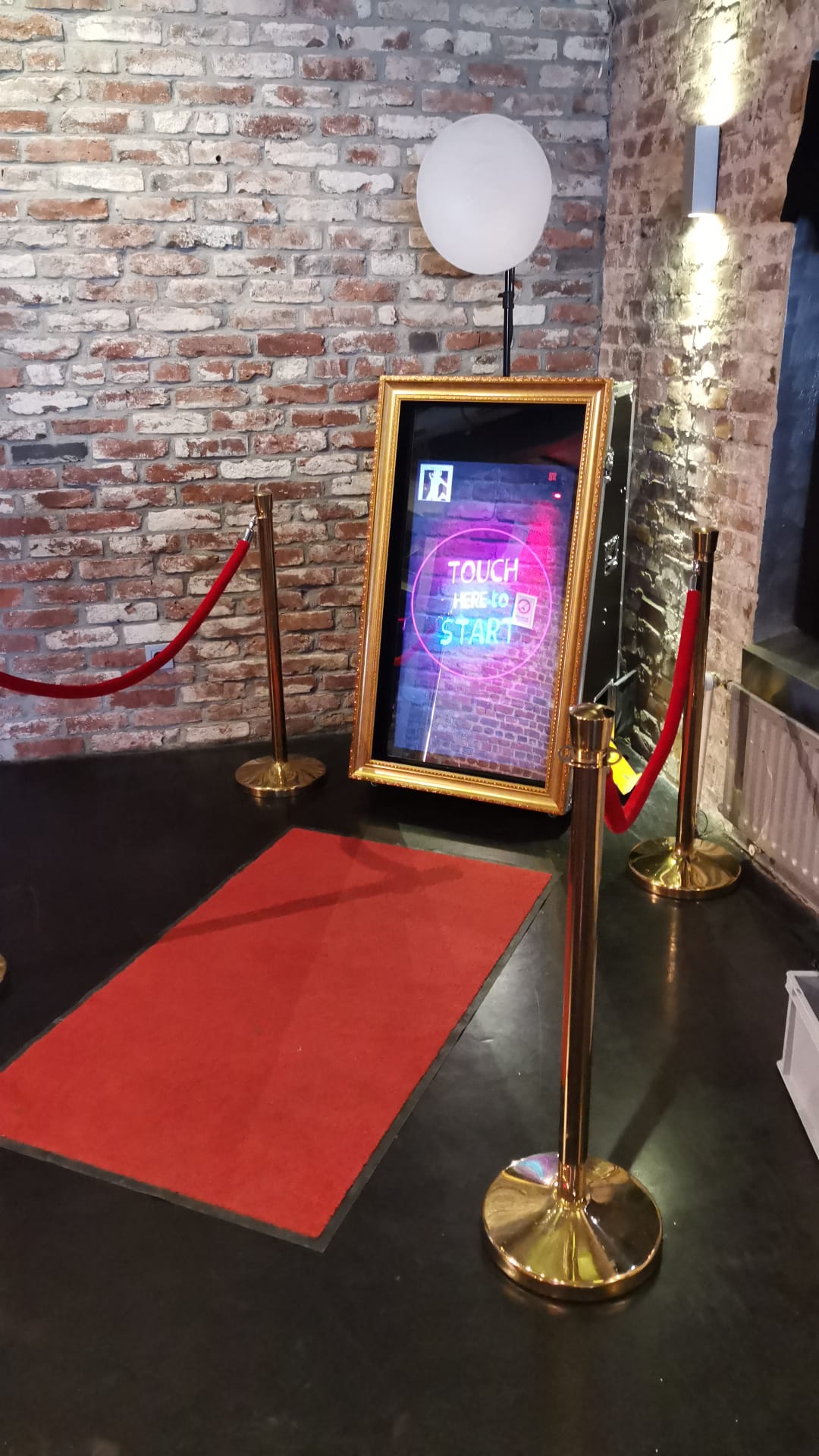 Magic Mirror Fotospiegel im Goldrahmen mit rotem Teppich und goldenen VIP-Ständern auf einem Event